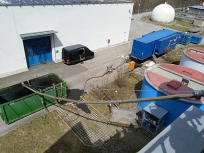 Der abgepumpte Schlamm wird im grünen Container gespeichert und von der Anlage im blauen Container entwässert